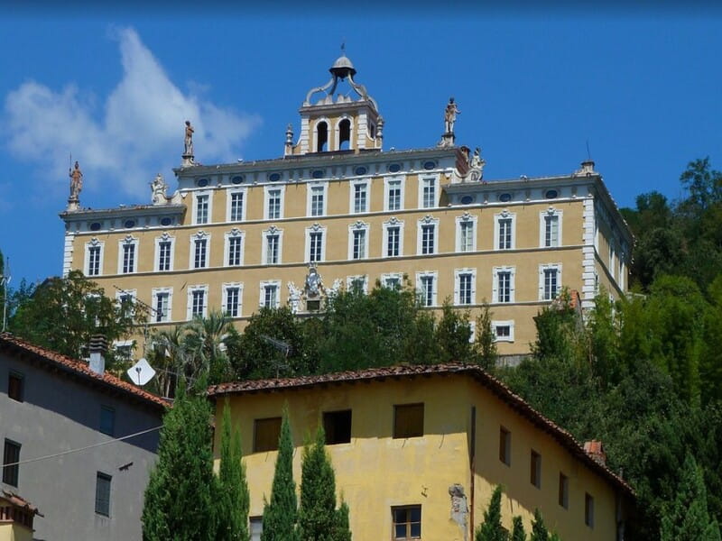 Veduta monumentale della facciata barocca e delle statue di Villa Garzoni a Collodi, immersa nel verde della Toscana.