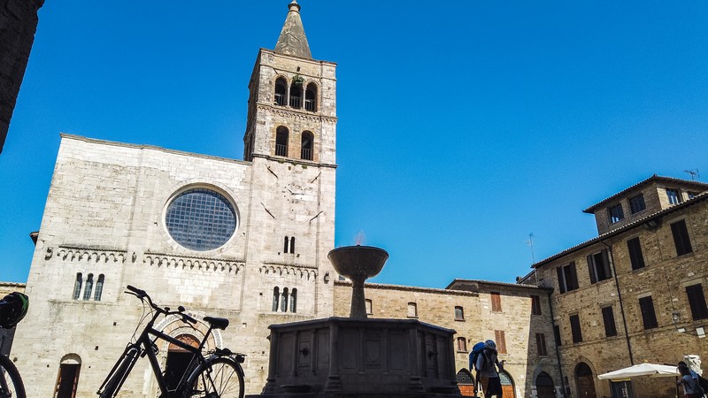 Piazza Filippo Silvestri è una delle attrazioni da vedere a Bevagna. In primo piano la fontana gotica e sullo sfondo si erge la facciata della chiesa di San Michele col suo alto campanile.