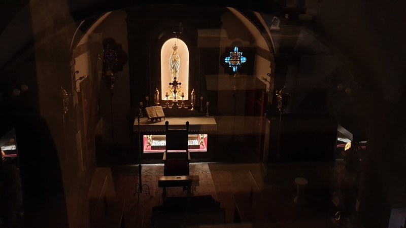 Un piccolo altare che si trova all'interno della cripta della Collegiata di San Andrea a Montecarlo di Lucca. Al centro illuminata una statua della Madonna con sotto una teca.
