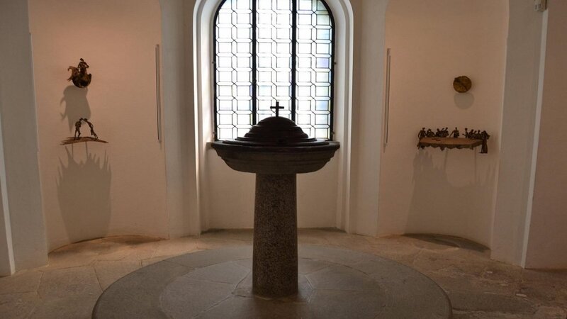 La fonte battesimale della chiesa di santa croce a vinci. Si trova nel mezzo di una stanza circolare e dietro c'è una grande finestra che fa penetrare la luce.