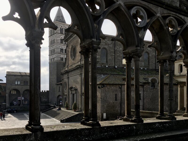 uno scorcio sulla maestosa cattedrale di viterbo dalle arcate del palazzo dei papi