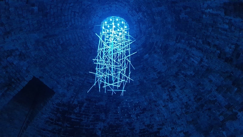 una cascata di luci azzurre appese al soffitto della torre centrale della rocca di staggia che illuminano tutta la zona di celeste e creano un ambiente molto suggestivo