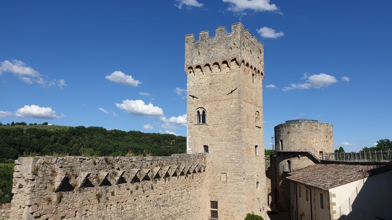 un camminamento merlato che conduce al grande ed imponente mastio quadrato della Rocca di Staggia. A metà della struttura due finestrelle mentre sulla cima l'imponente merlatura difensiva.