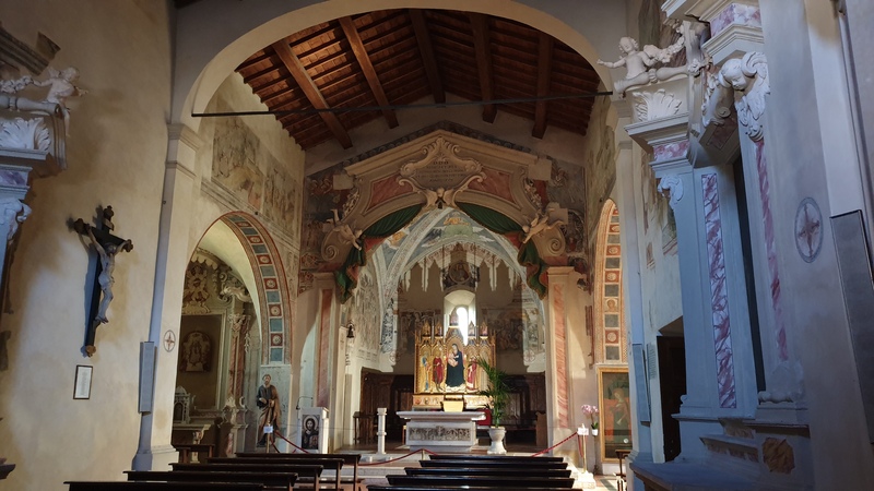 l'interno della chiesa di San Giorgio a Montemerano, in primo piano sulla destra un grande crocifisso ligneo mentre sullo sfondo la pala d'oro raffigurante la madonna e gli affreschi sulla volta