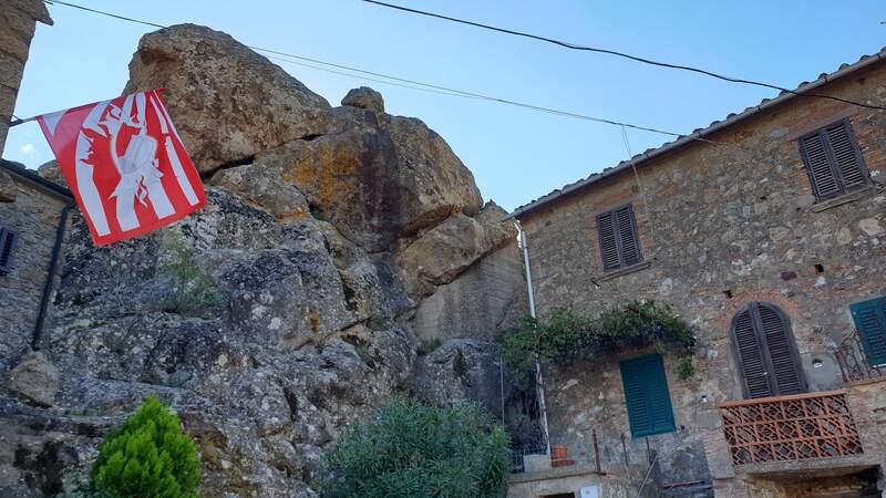 uno sperone di roccia pura che esce fuori dal terreno e che si fa strada nel mezzo delle case medievali del centro storico di roccatederighi.