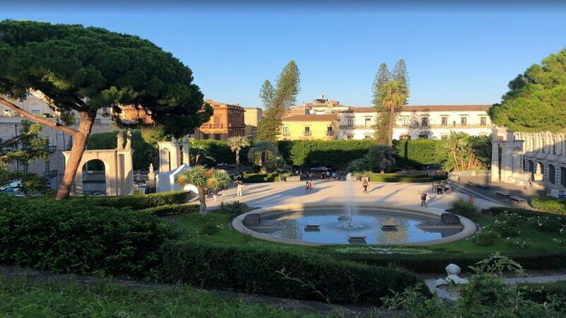 Scorcio del Giardino Bellini di Catania con alberi secolari e vialetti panoramici.
