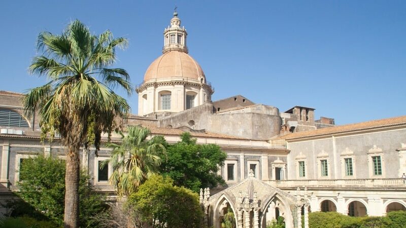 Veduta del chiostro e della cupola del Monastero dei Benedettini di Catania, tra arte barocca e natura.