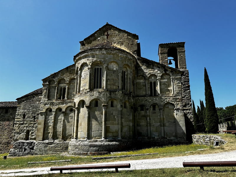 Il retro della Pieve di Romena con la sua torre campanaria, immersa nel paesaggio toscano.
