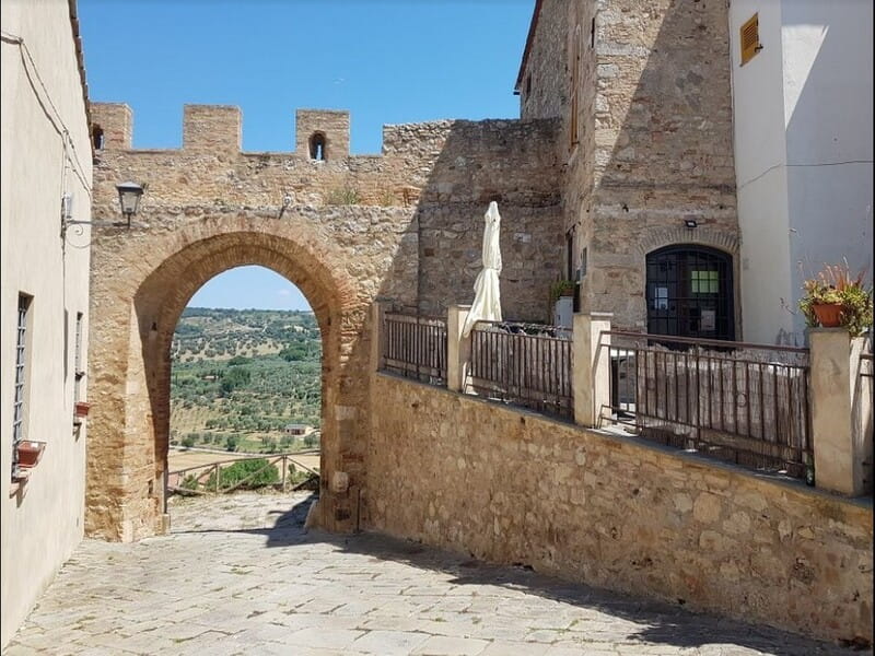 Porta merlata di accesso a Magliano in Toscana con vista sulle colline, uno dei luoghi più scenografici da includere in un itinerario in Maremma