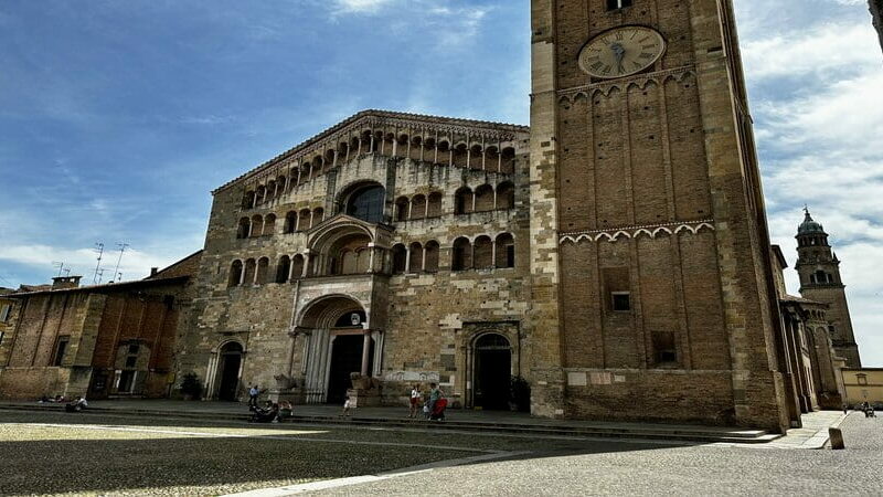 Primo piano sulla facciata romanica del Duomo di Parma con la torre campanaria, tappa imprescindibile tra cosa vedere a Parma in un giorno per scoprire il cuore spirituale della città