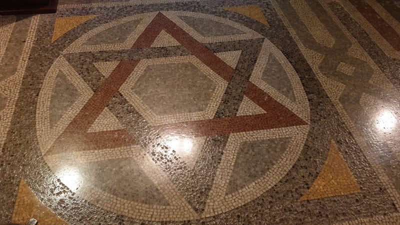 Dettaglio del mosaico con stella di David sul pavimento della sinagoga, simbolo della fede e dell’identità ebraica.